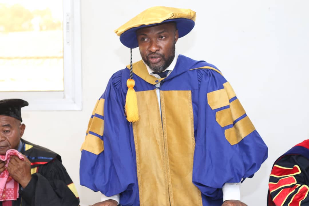 A doctoral graduate of ICOF Global University in blue and gold academic dress